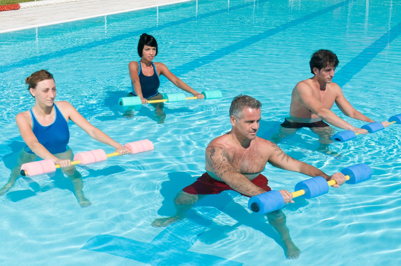 Мужчины и женщины занимаются фитнесом в бассейне