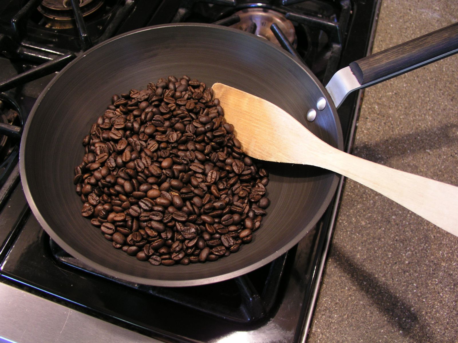 кофейные зерна в сковороде на плите