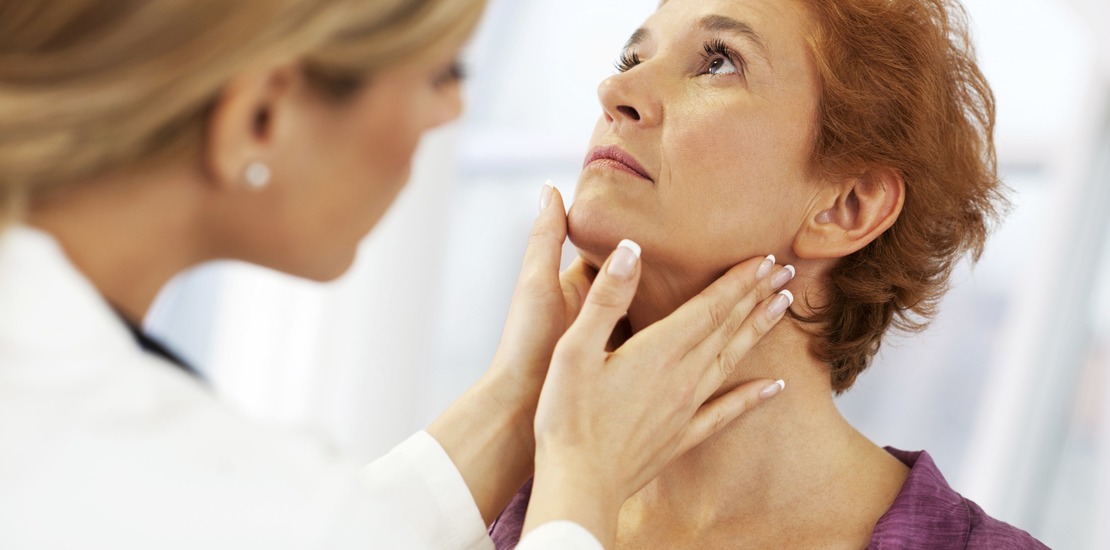 доктор осматривает щитовидную железу женщине