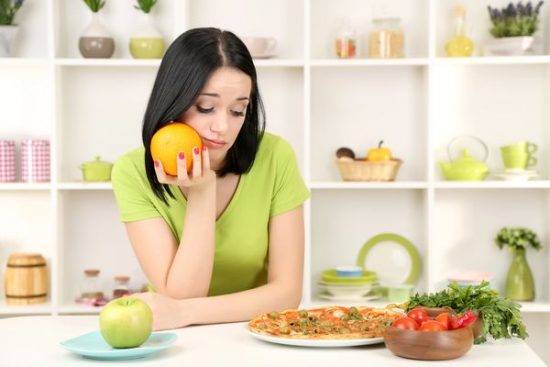 девушка на кухне с апельсином в руке